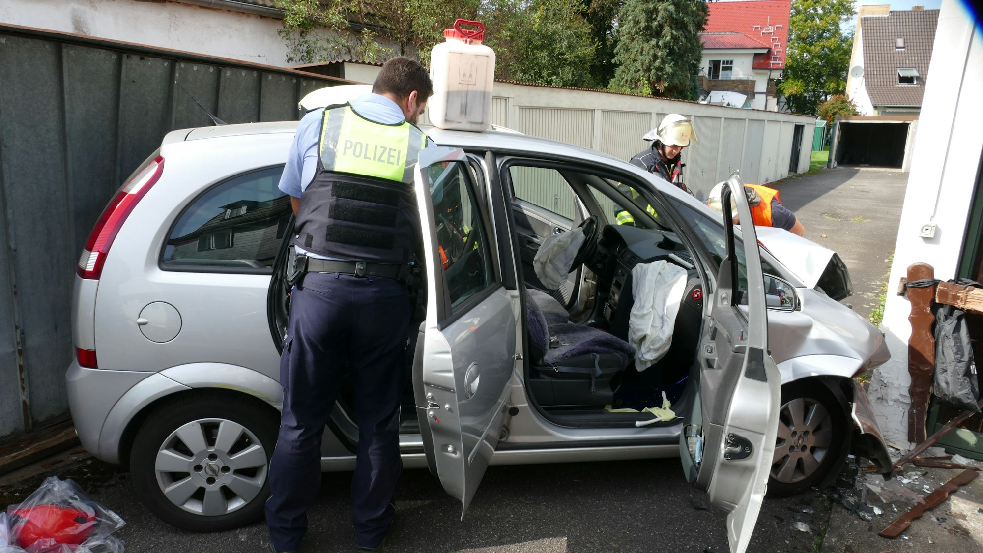 Ein Polizist steht vor einem Unfallwagen.