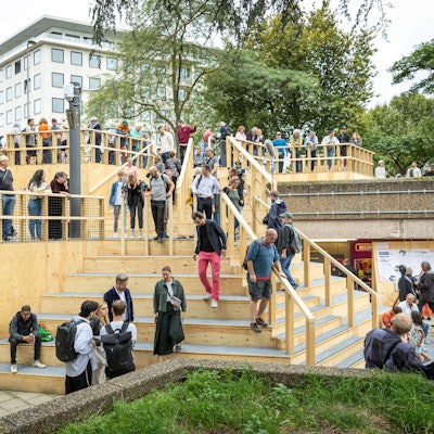 Menschen stehen auf der neuen Holztreppe am Ebertplatz.