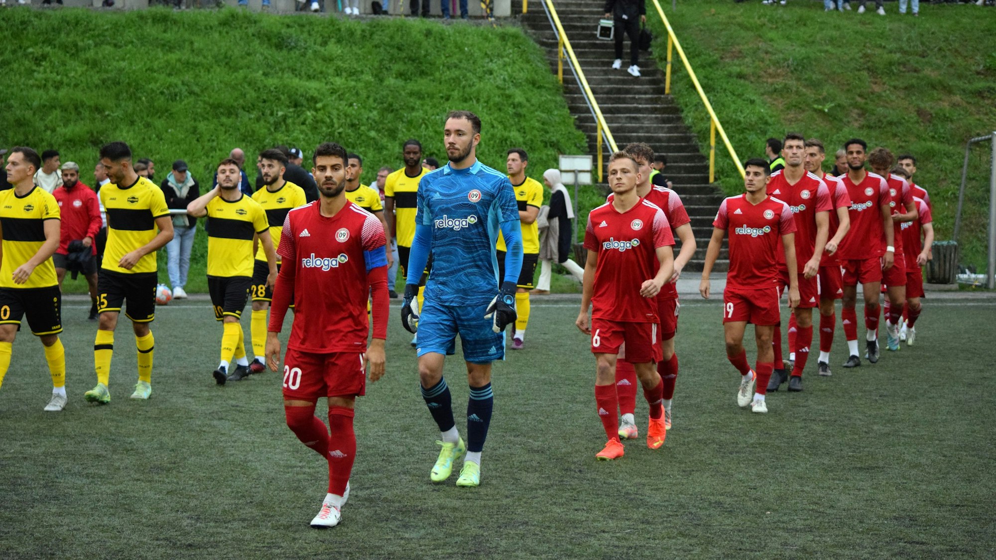 Zwei Mannschaften beim Einlauf vor einem Fußballspiel.
