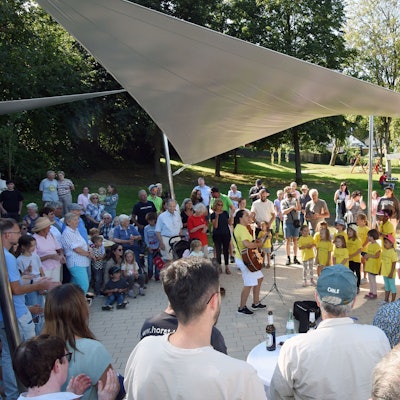 Ein Kinderchor wird von Festbesuchern umringt.