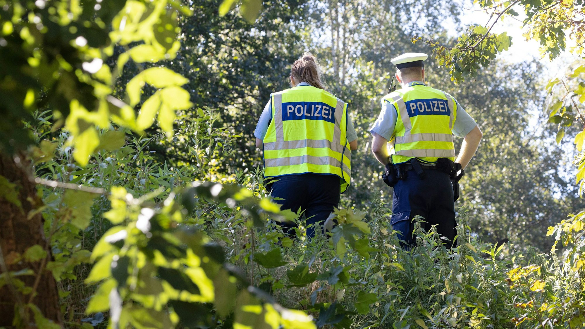 Polizisten sichern einen möglichen Tatort an einem Bahndamm im Hamburger Stadtteil Lokstedt.