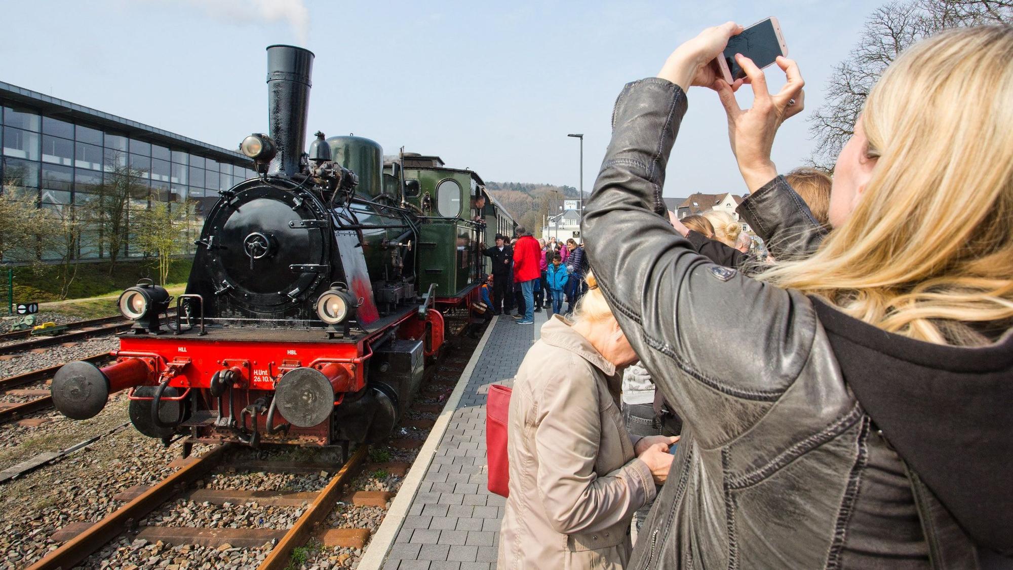 Am Wiehler Bahnhof fotografiert eine Frau eine Dampflok.