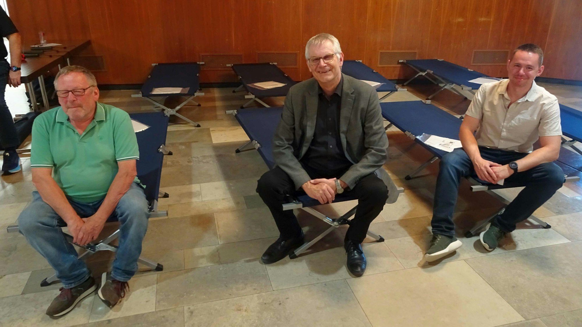 Auf Feldbetten: Bürgermeister Ludger Banken (Mitte), Peter Heck (UWG, links) aus Oberdrees und Pascal Gressmann, Sachbearbeiter Bevölkerungs- und Katastrophenschutz der Stadt Rheinbach.