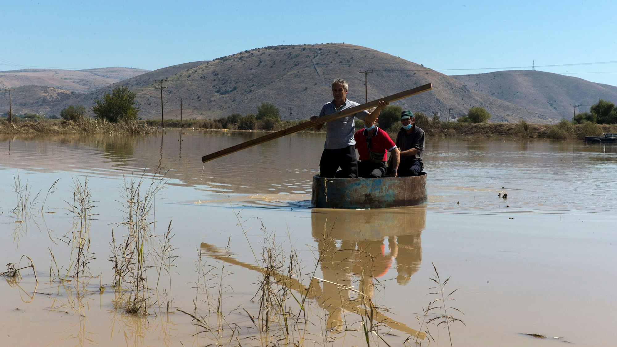 Ein Bootsführer transportiert Passagiere durch ein überschwemmtes Gebiet. In den von Überschwemmungen betroffenen Gebieten Mittelgriechenlands sind die Wasserstände weiter gesunken.