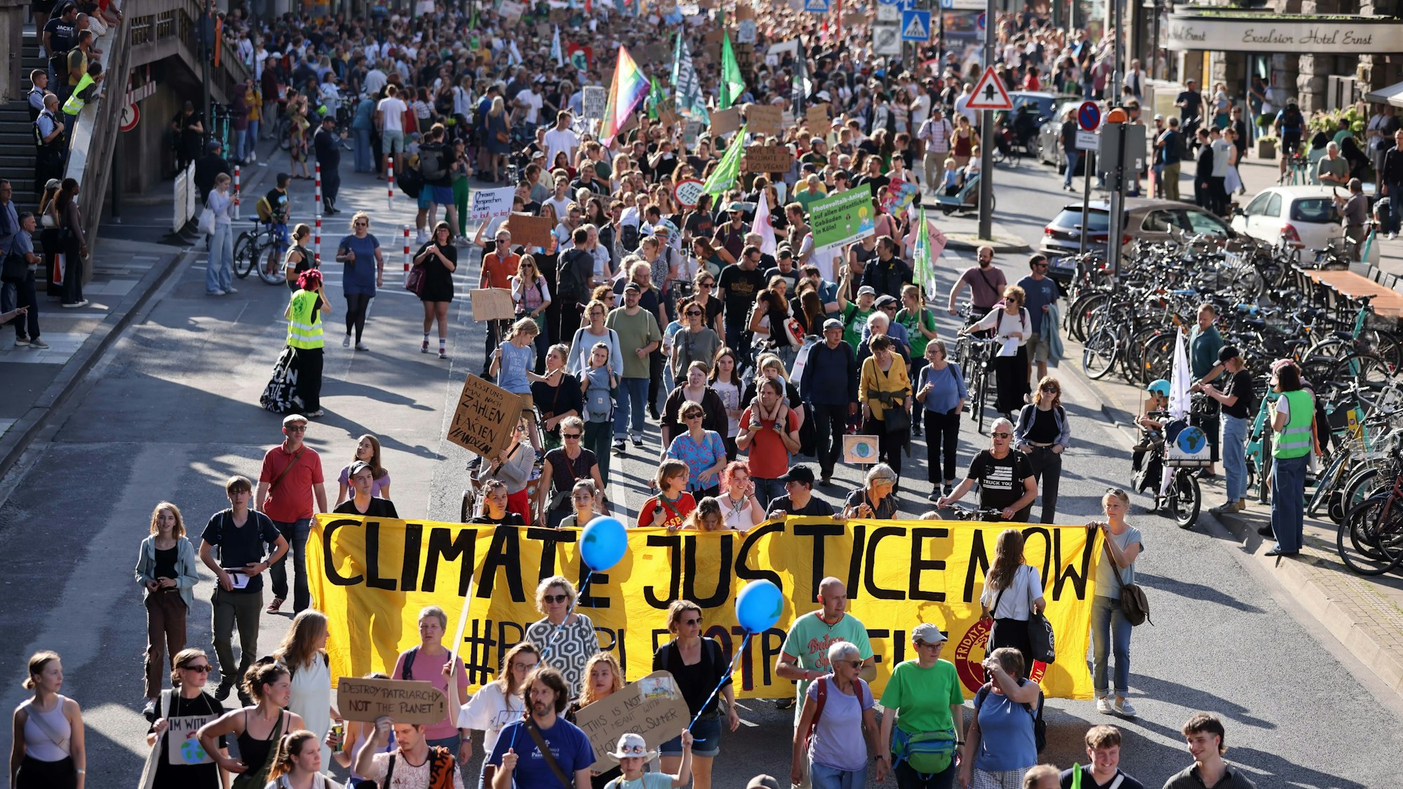 Eine Gruppe Menschen zieht mit Demoschildern über die Komödienstraße.