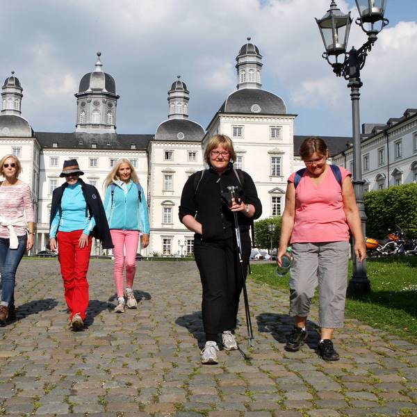 Wanderer wandern vom Bensberger Schloss aus los.