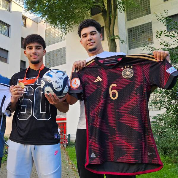 Auf dem Foto halten Fayssal, sein Vater Mohammed und Bruder Imad Trikots in die Kamera.