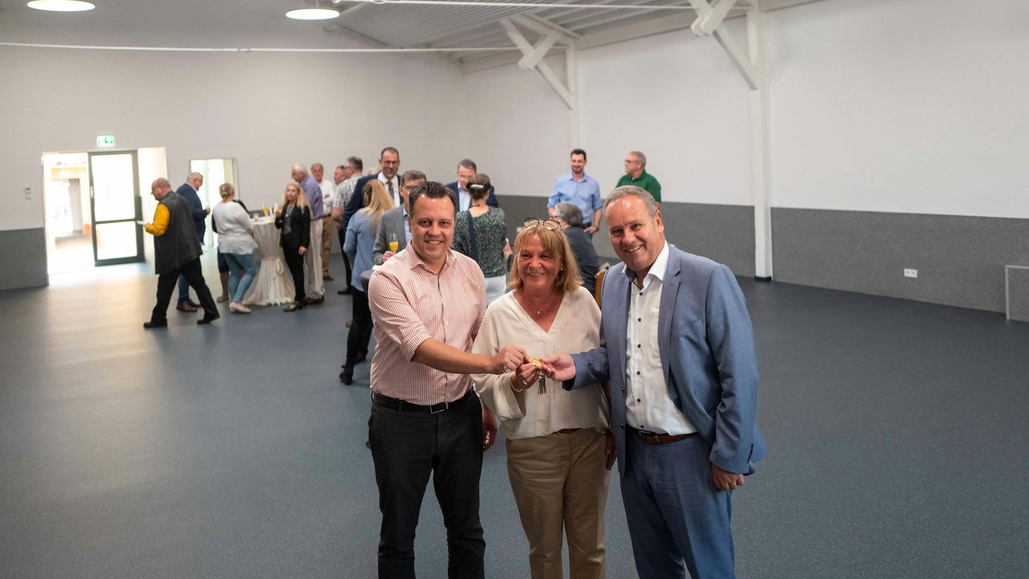 Das Bild zeigt die glückliche Dagmar Klöcker, wie sie einen Schlüssel erhält.