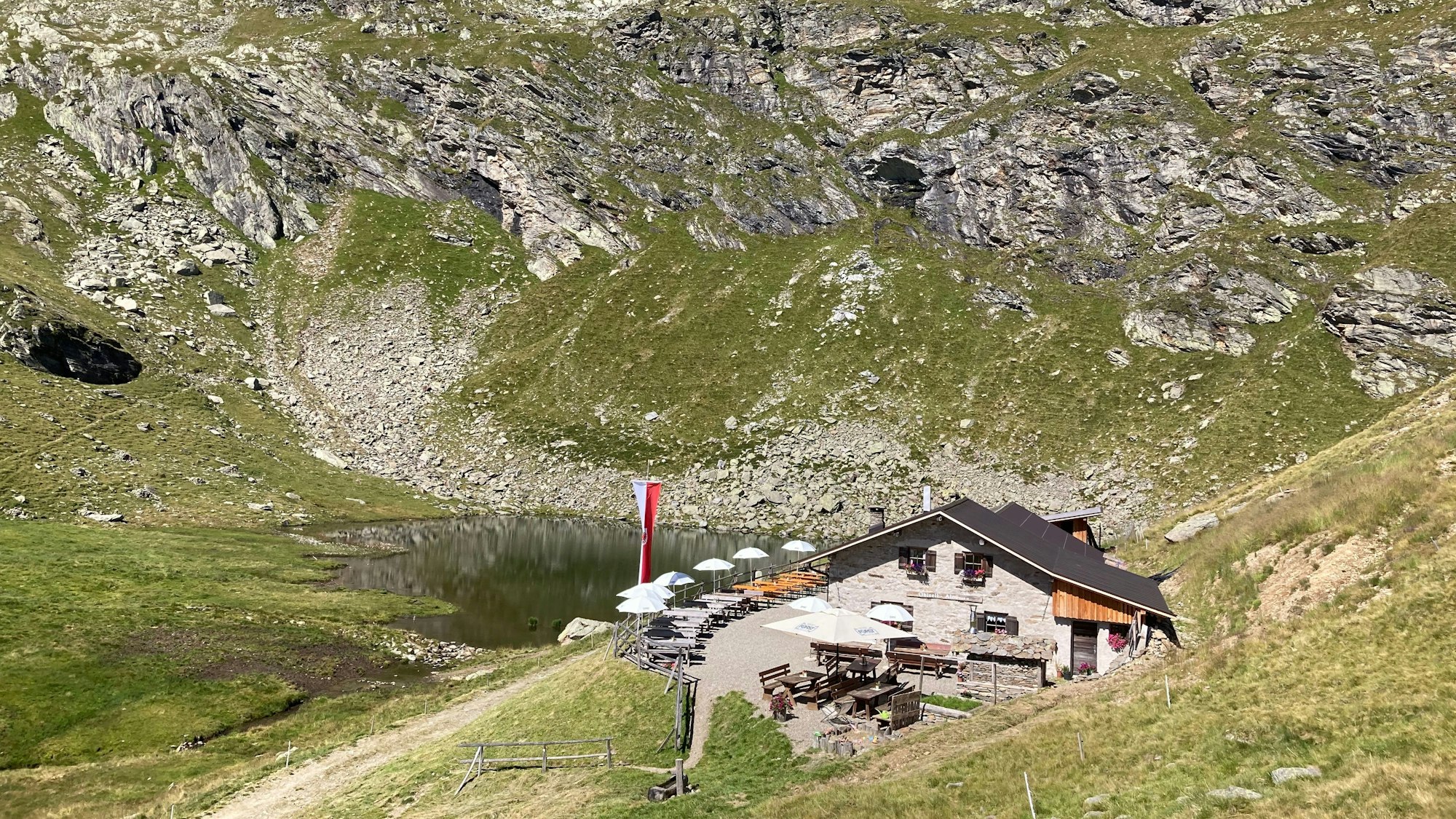 Eine Bergalm in Südtirol mit Terrasse für Wanderer.