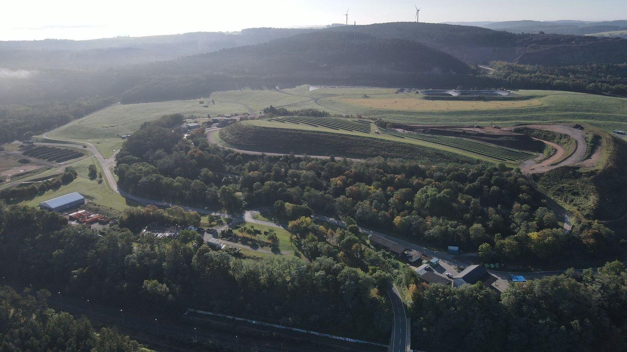 Eine Luftaufnahme zeigt ein Abfallwirtschaftszentrum, umgeben von Bäumen.