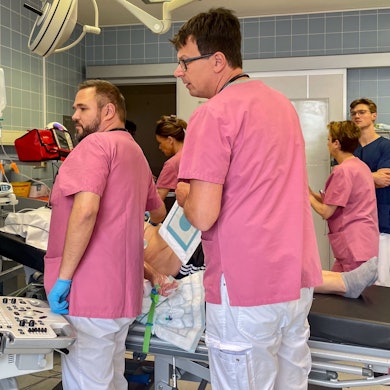 Mehrere medizinische Mitarbeiter in der Notaufnahme des Euskirchener Marienhospitals bei ihrer Arbeit. Ein Patient (verdeckt) liegt auf dem Behandlungstisch.