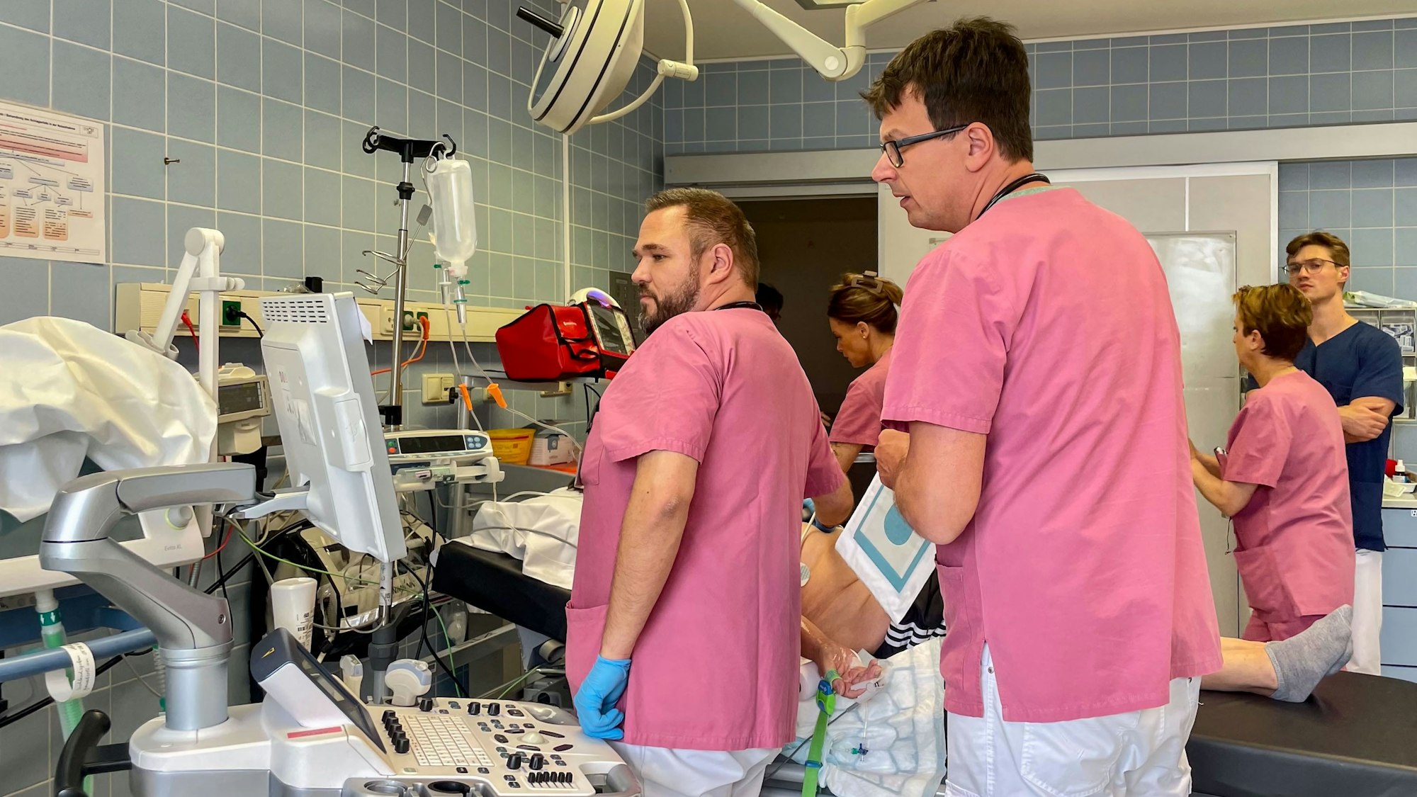 Mehrere medizinische Mitarbeiter in der Notaufnahme des Euskirchener Marienhospitals bei ihrer Arbeit. Ein Patient (verdeckt) liegt auf dem Behandlungstisch.