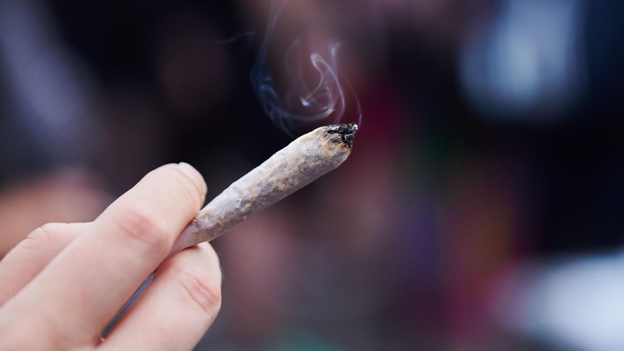 Eine Frau hält einen Joint mit Cannabis in der Hand. In Hamburg werden Stimmen lauter, die die Cannabis-Legalisierung nicht hinnehmen wollen. (Symbolbild)