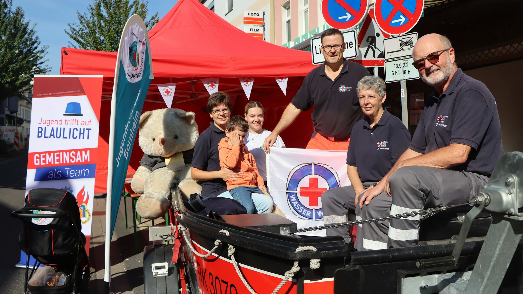 Mitglieder von Wasserwacht und DRK sitzen in einem Boot und stellen ihre Arbeit vor.