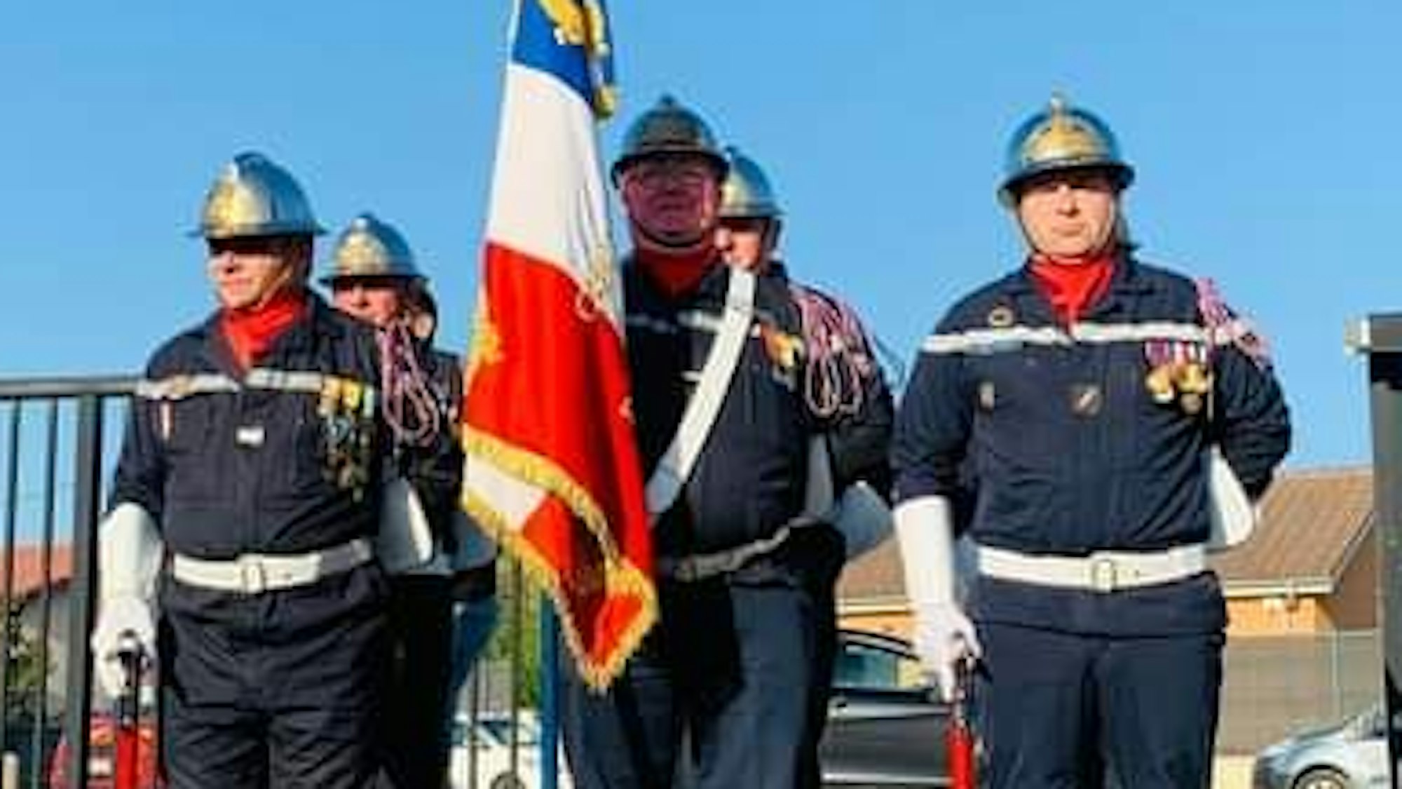 Französische Feuerwehrleute sind mit einer Fahne angetreten.