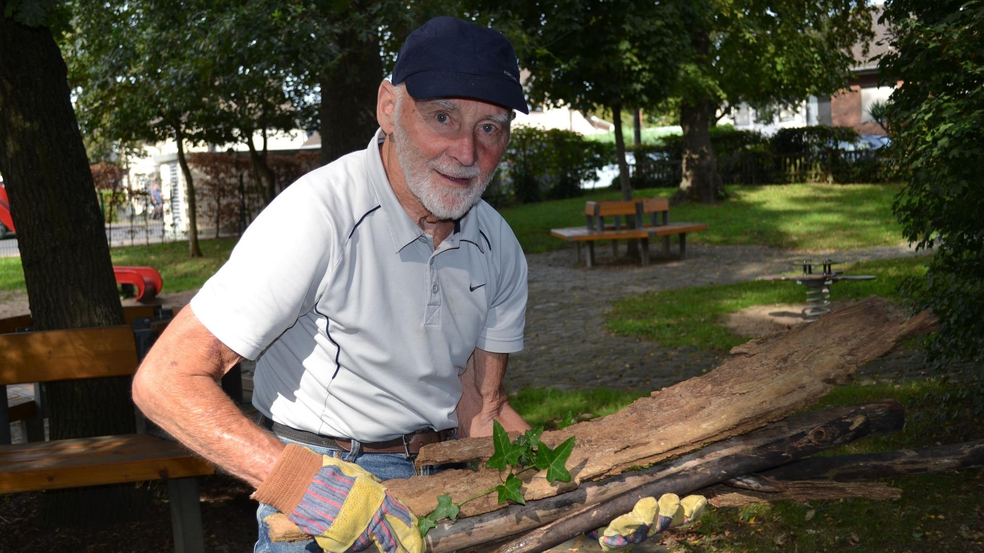 Georg von Schrader hat Äste im Arm, die er gesammelt hat.