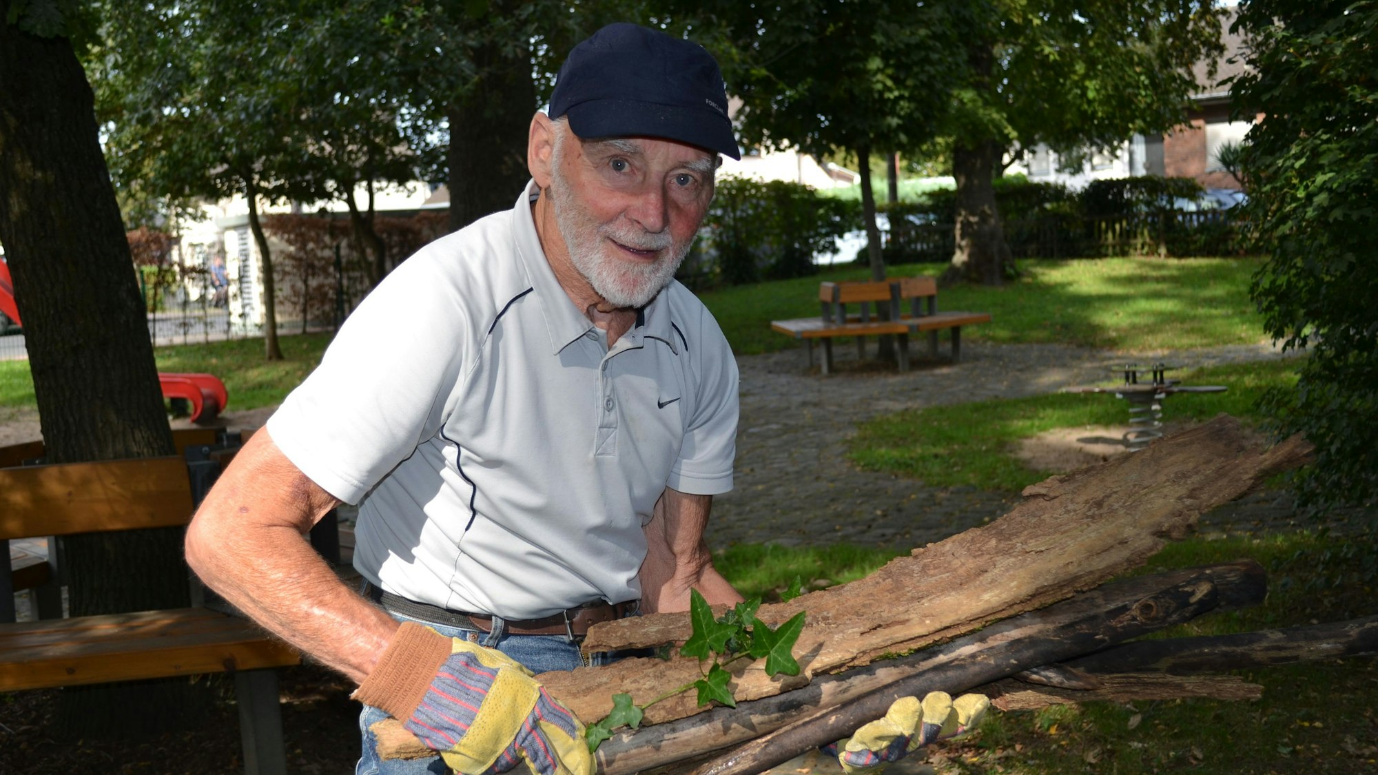 Georg von Schrader hat Äste im Arm, die er gesammelt hat.