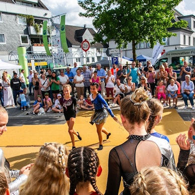 Zahlreiche Menschen schauen in Marienheide Kindern beim Tanz zu.