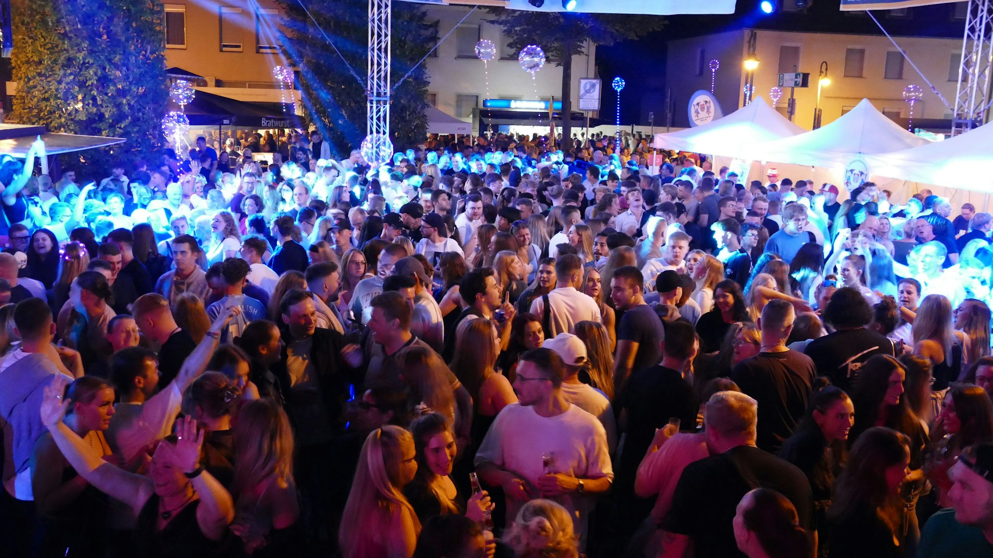 Hunderte junger Menschen tanzen auf dem Platz.