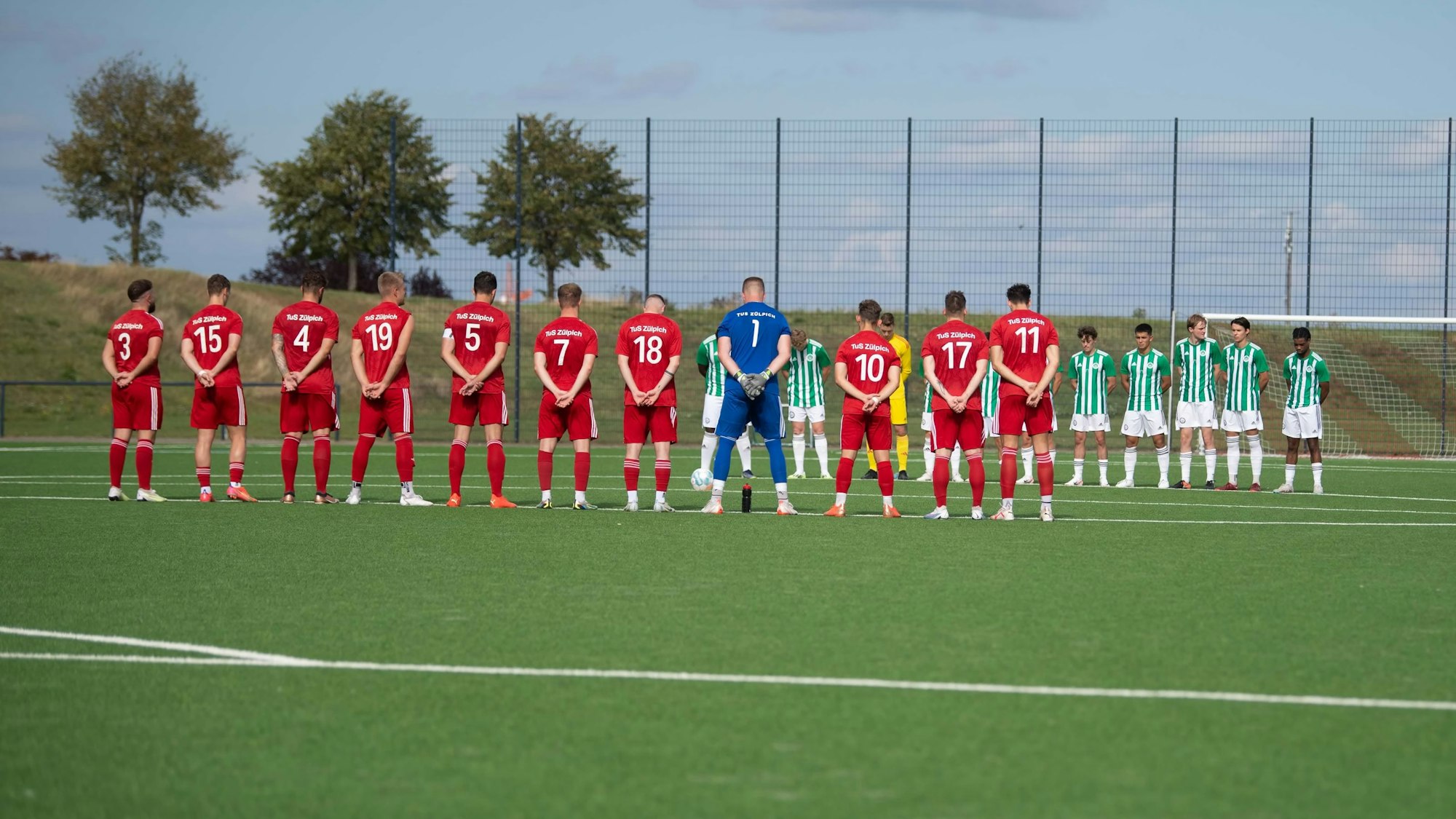 Das Bild zeigt die Mannschaften aus Zülpich und Brauweiler während der Schweigeminute.