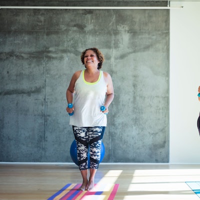 zwei Frauen mit Hanteln auf Sportmatten