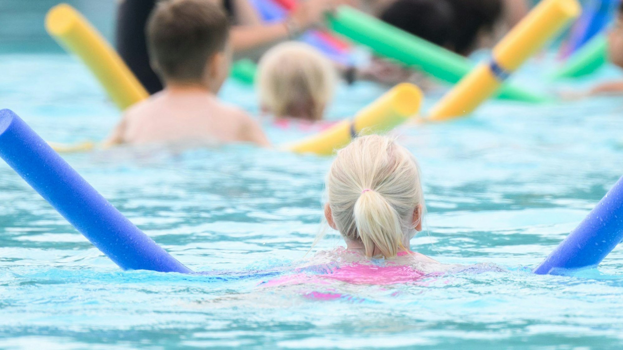 Viel zu wenig Wasserzeiten für Schwimmunterricht gibt es in den Kölner Bädern. Jetzt schafft ein mobiler Container zumindest etwas Abhilfe. Kinder lernen mit Hilfe von Schwimmnudeln das Schwimen