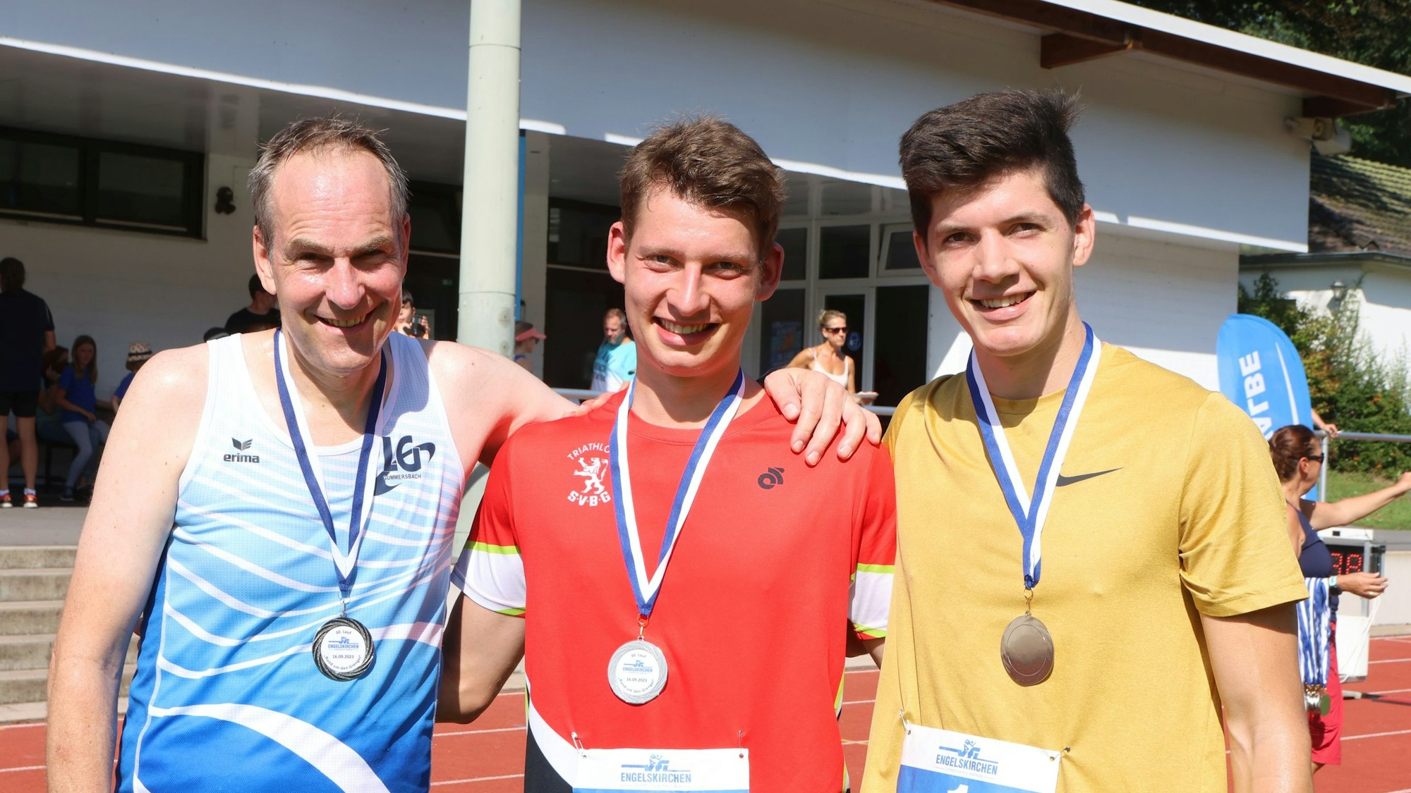 Die Sieger des Grengel-Llaufs stehen mit Medaillen zusammen im Stadion in Engelskirchen.