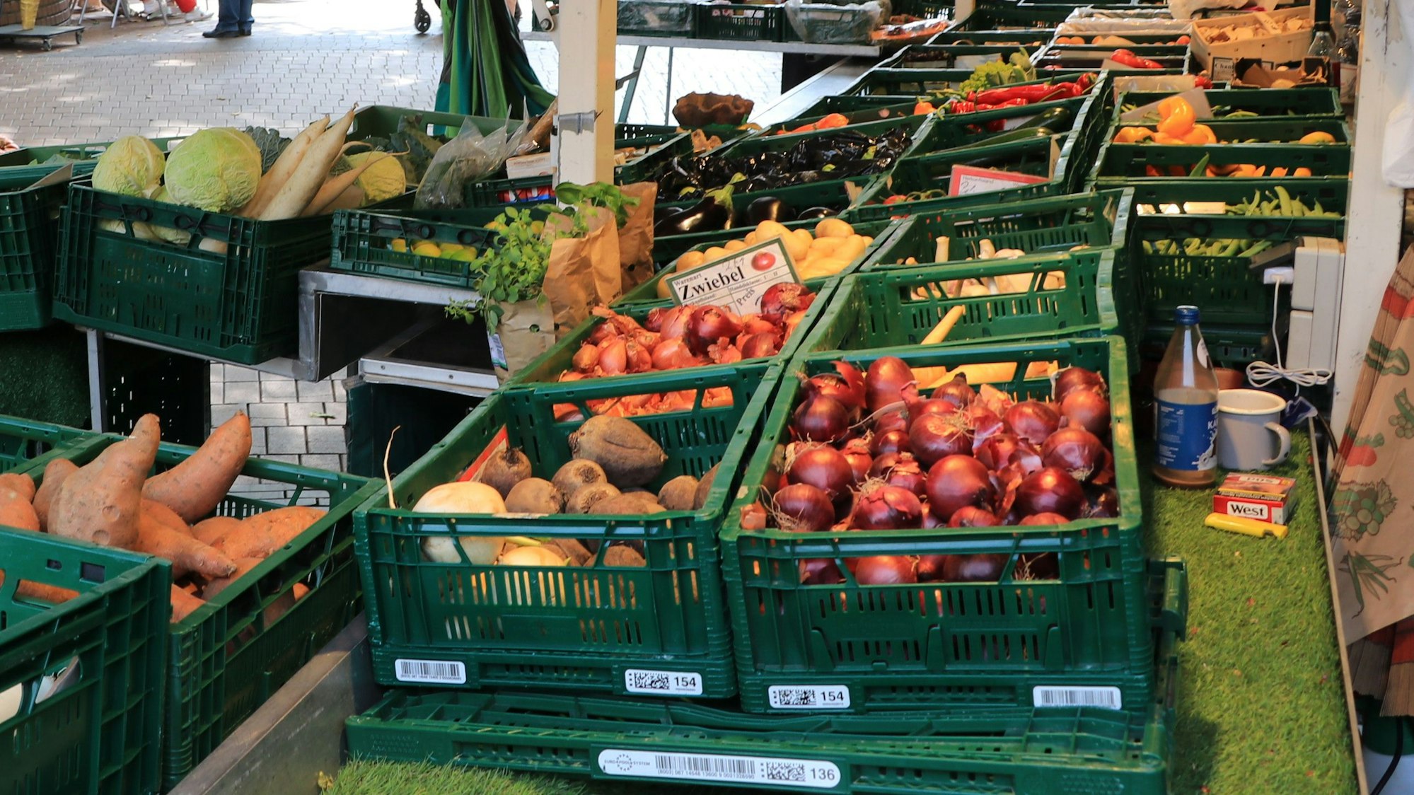 An einem Marktstand werden Obst und Gemüse präsentiert.