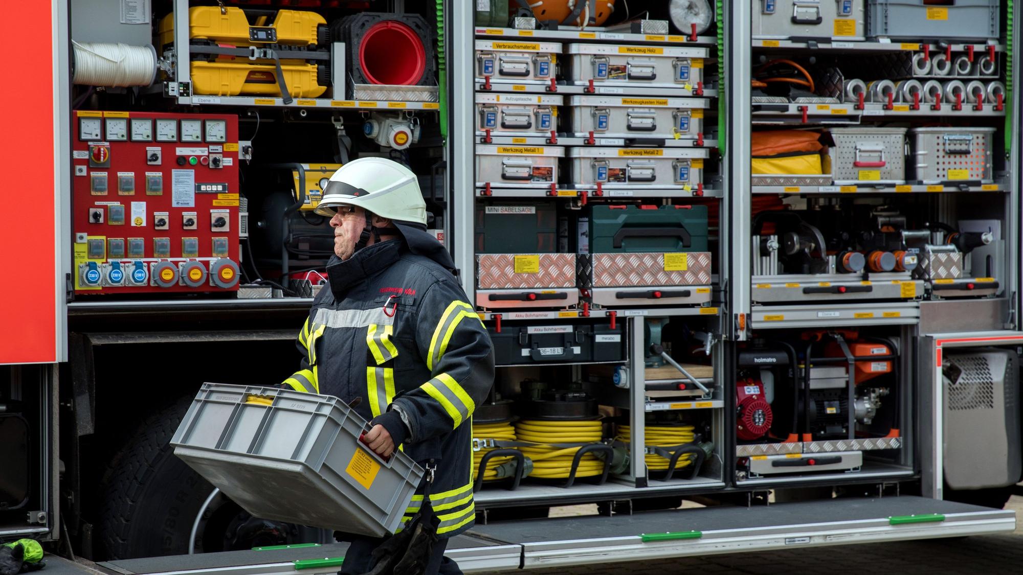 Ein Feuerwehrmann räumt einen Feuerwehrwagen ein.