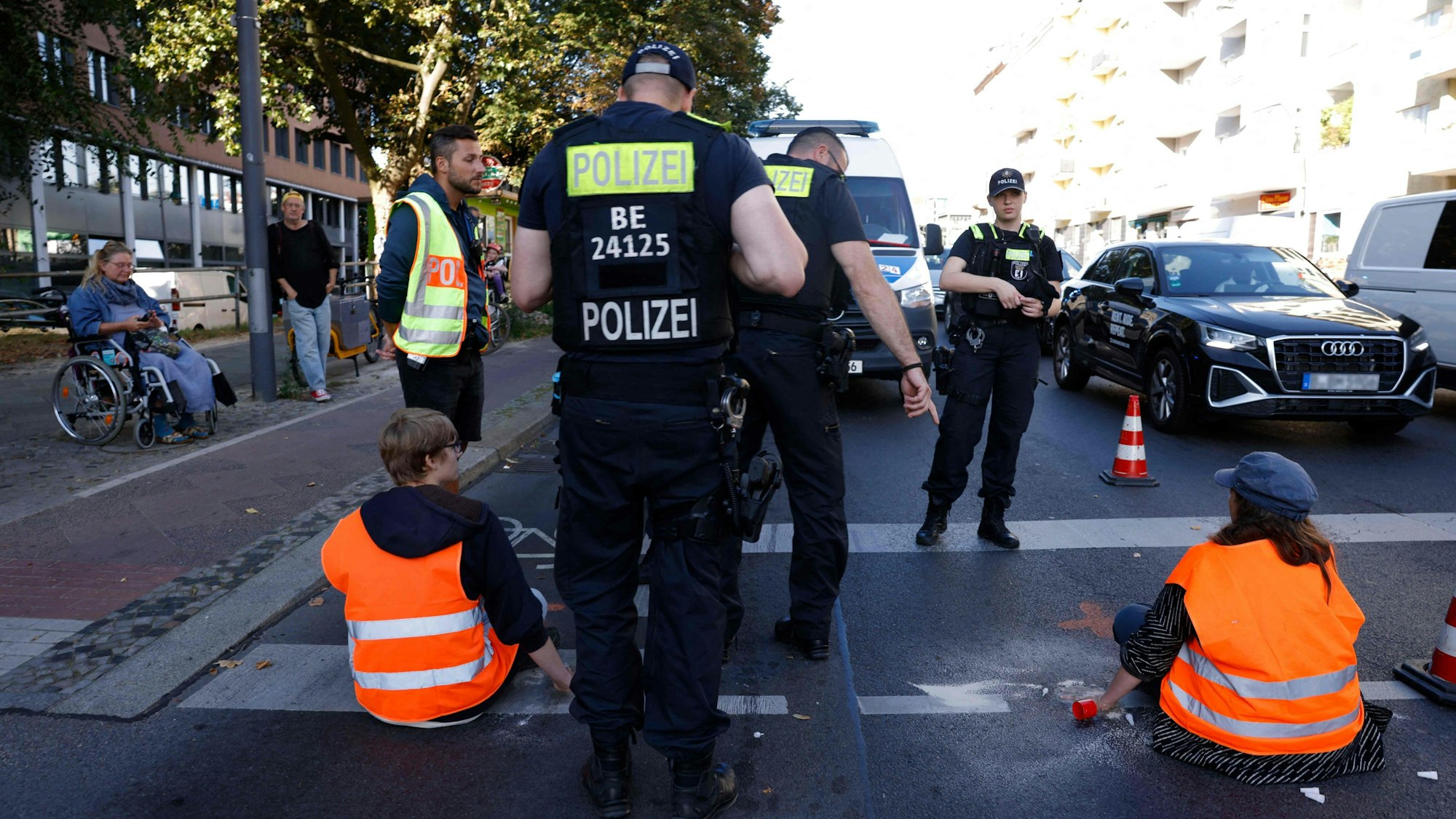 In Berlin legt die Letzte Generation den Verkehr auf vielen Straßen lahm. Polizisten greifen ein.