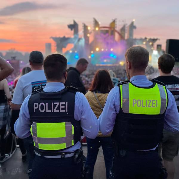 Das Bild zeigt die beiden Polizisten, wie sie auf die Bühne des Festivals schauen.
