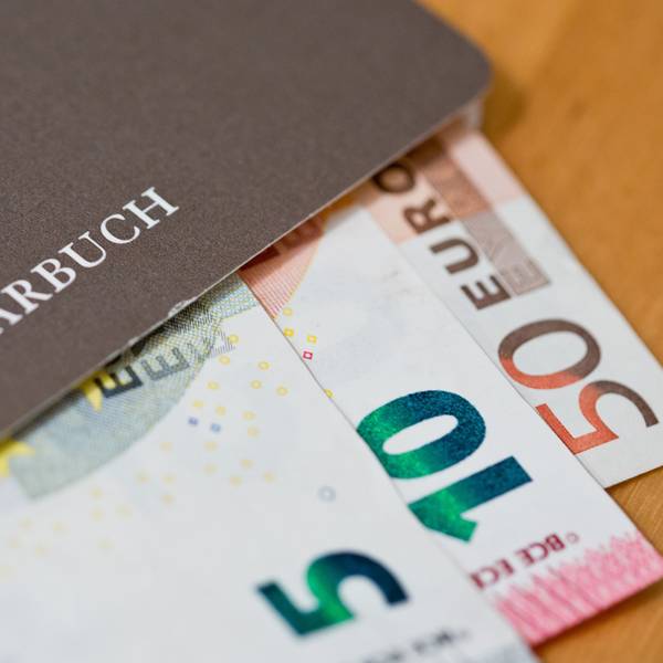 Geldscheine (Euro) liegen in einem Sparbuch.