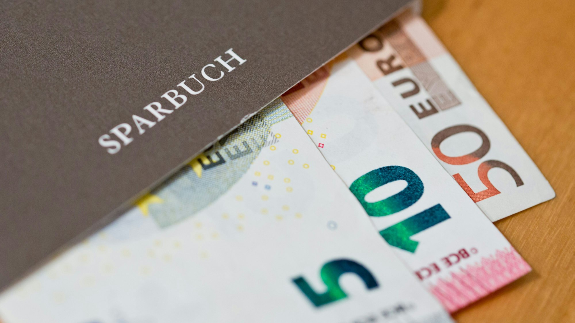 Geldscheine (Euro) liegen in einem Sparbuch.