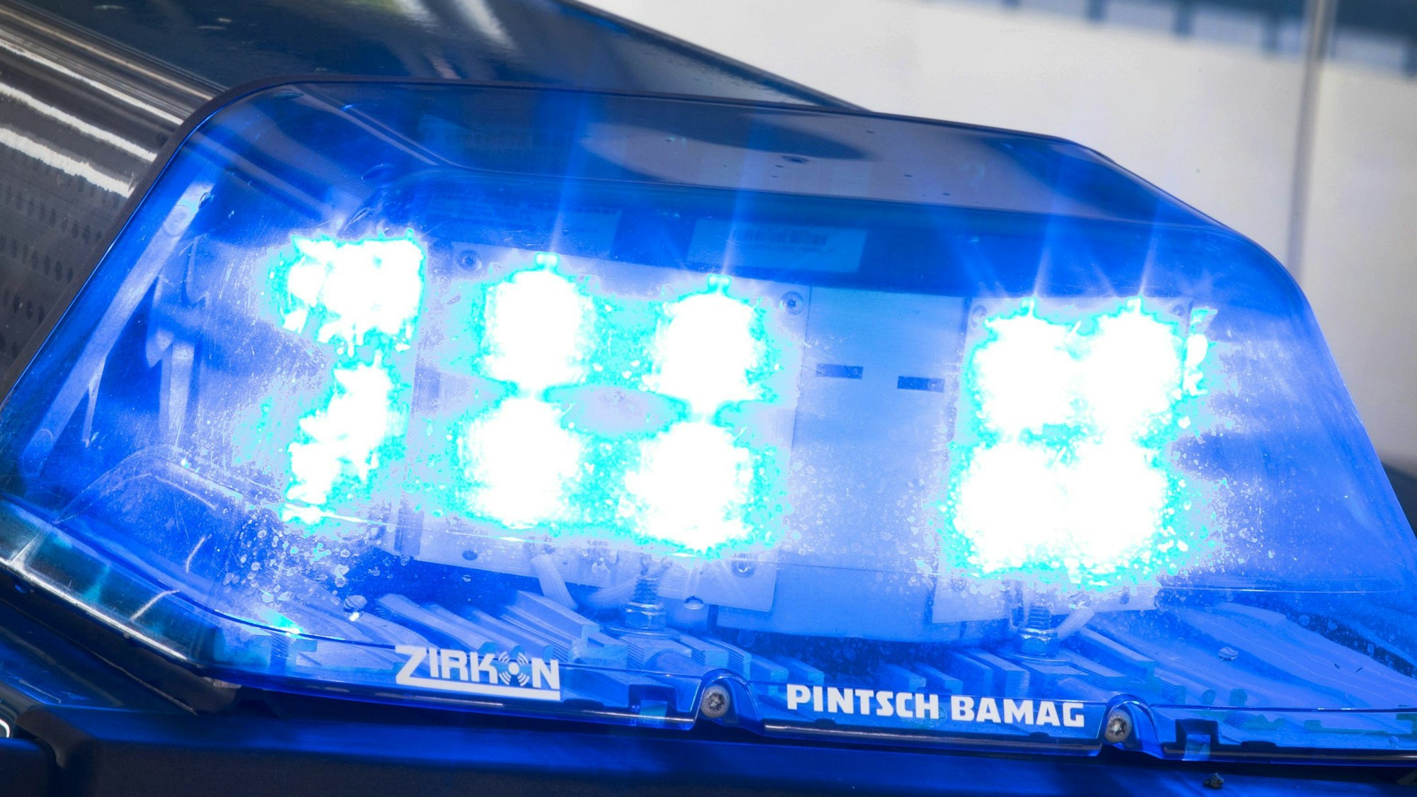 Ein Blaulicht leuchtet auf dem Dach eines Polizeiwagens.