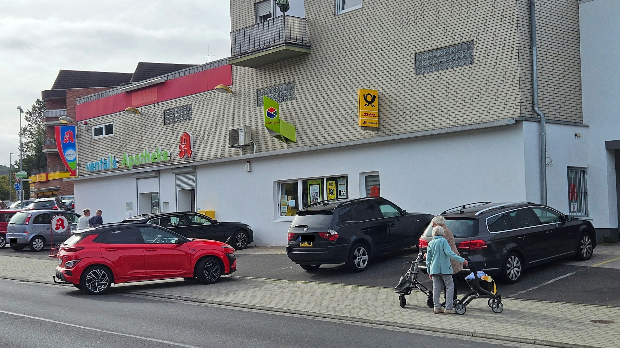 Zu sehen ist die Filiale der Deutschen Post in Gemünd mit davor parkenden Autos.