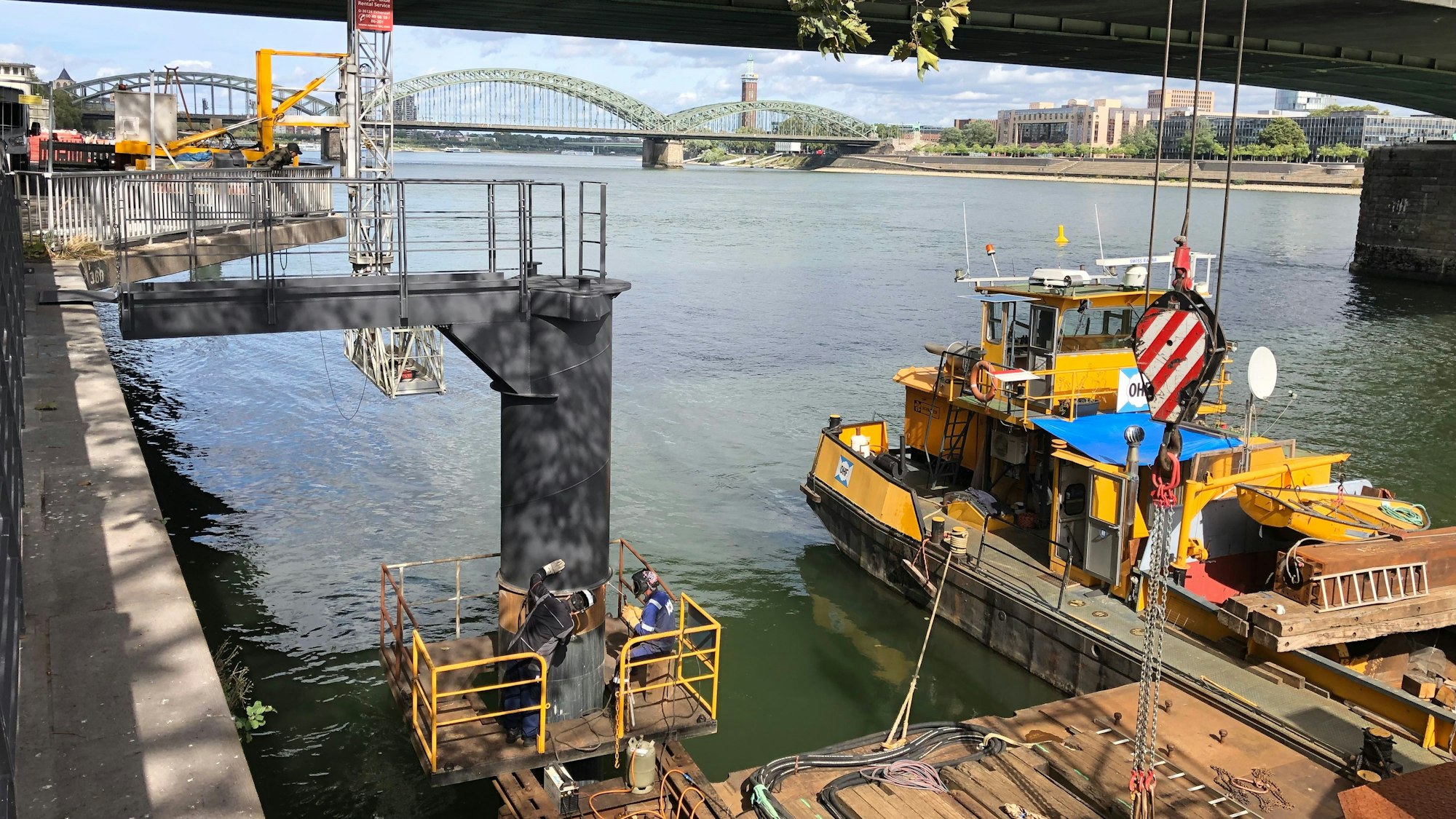 Schweißer arbeiten an einer Anlegevorrichtung für Rheinschiffe in Köln.