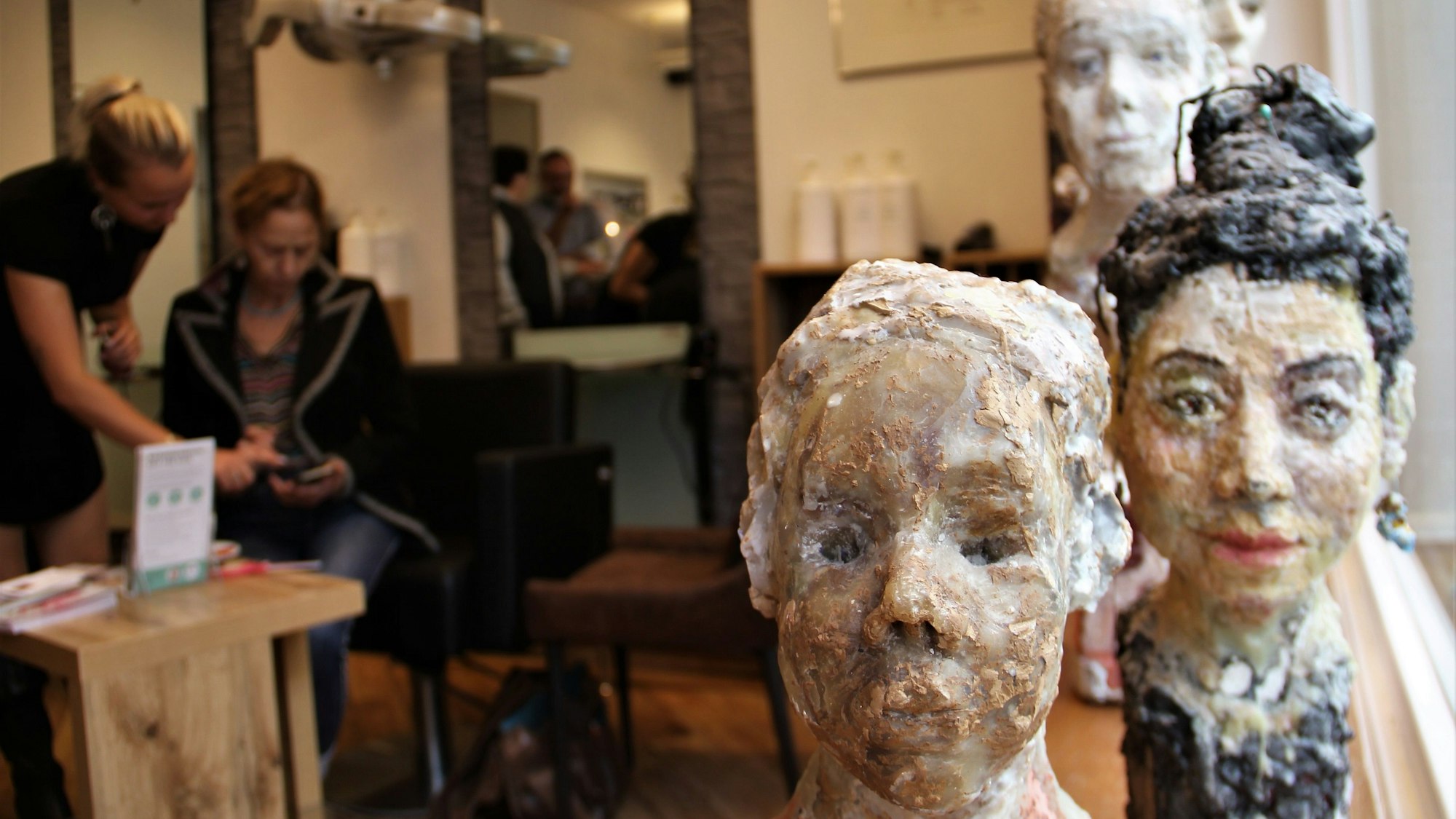 Kunst erobert in Sülz und Klettenberg wieder die Geschätfsläden – so wie hier die Wachsfiguren in „Die Haarschneider“.