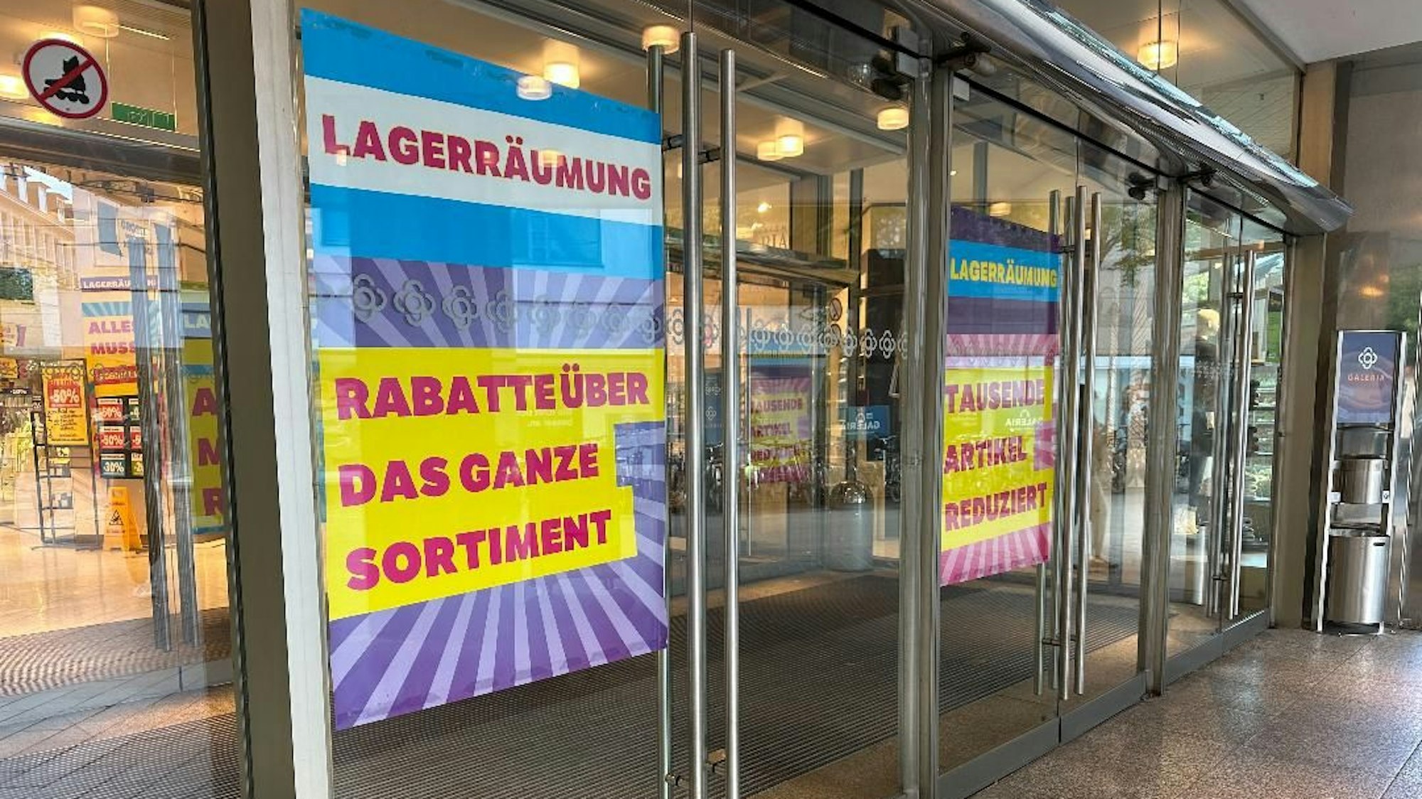 Große Plakate in einem Schaufenster weisen auf eine Lagerräumung hin.