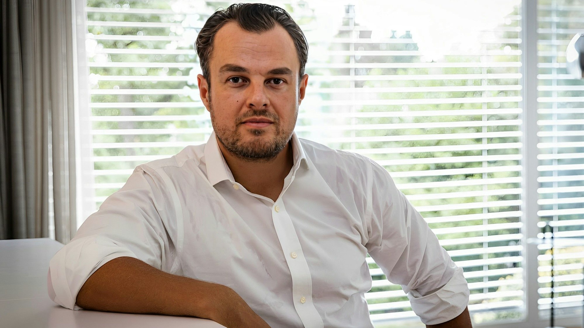 Dominik Matyka lehnt sich an einem Tisch an.