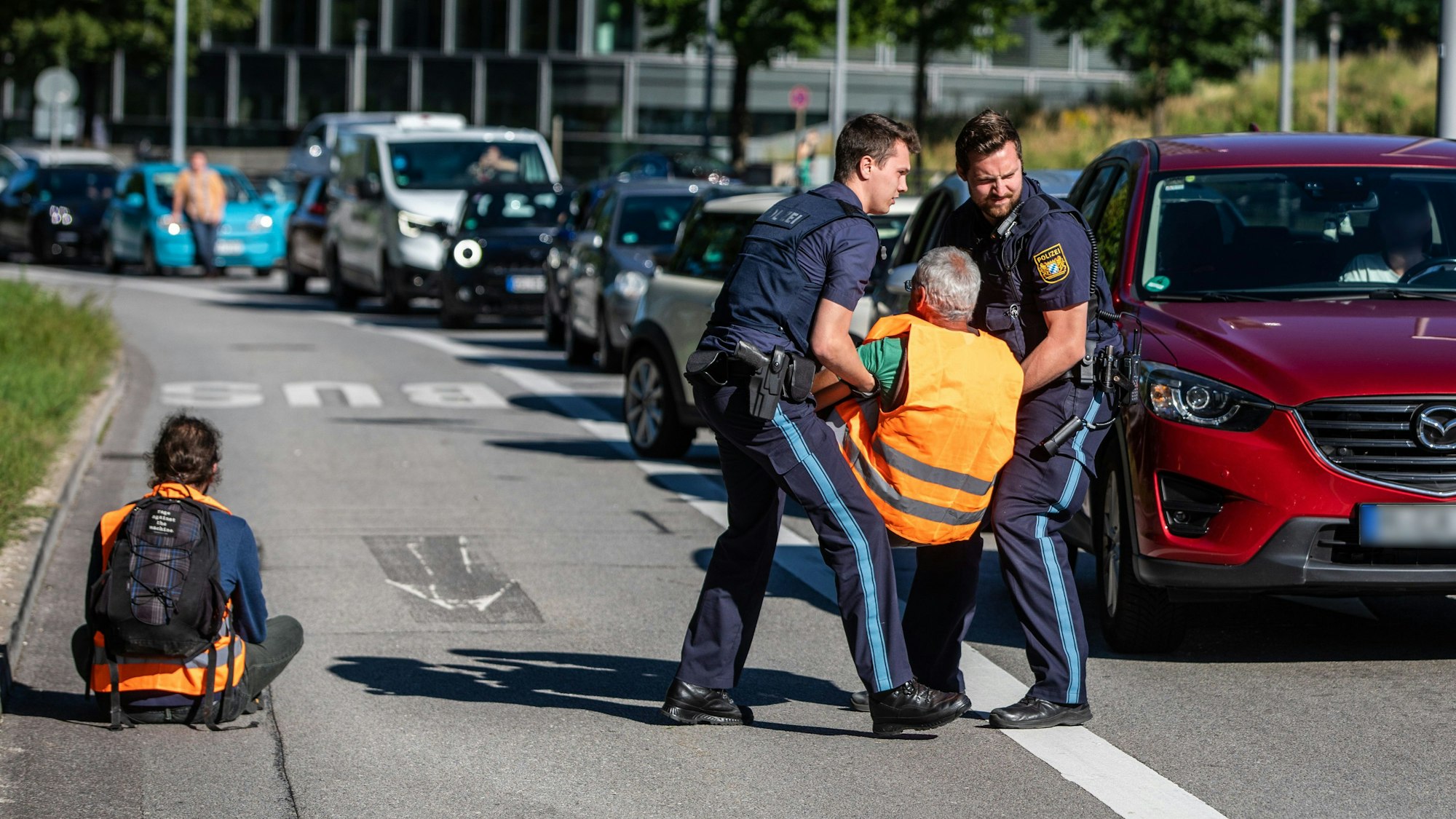 04.09.2023, Bayern, München: Polizeieinheiten entfernen Klimaaktivisten der ·Letzten Generation· von der Strasse. Die Teilnehmer waren Teil einer Straßenblockade, die sich gegen die IAA gerichtet hat. Die Aktion richtet sich gegen die IAA. Die Internationale Automobil-Ausstellung IAA MOBILITY 2023 findet in München von 05.-10. September statt. Foto: Christoph Schmidt/dpa +++ dpa-Bildfunk +++
