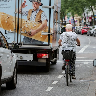An der Neusser Straße in Nippes herrscht dichter Verkehr. Autos parken dicht an dicht am Straßenrand.