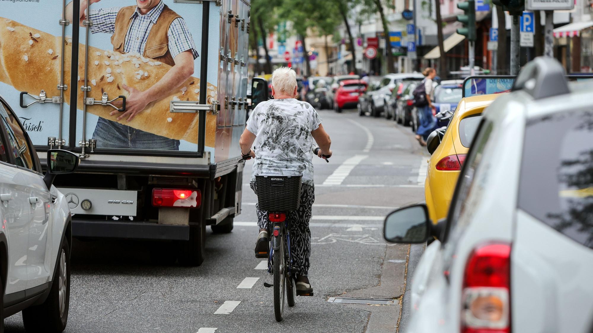 An der Neusser Straße in Nippes herrscht dichter Verkehr. Autos parken dicht an dicht am Straßenrand.