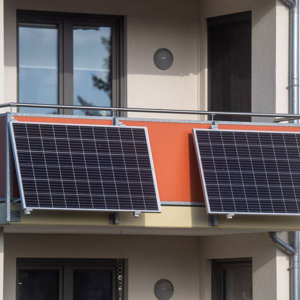 Das Foto zeigt zwei Solarmodule an einem Balkon.