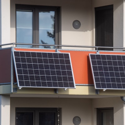 Das Foto zeigt zwei Solarmodule an einem Balkon.