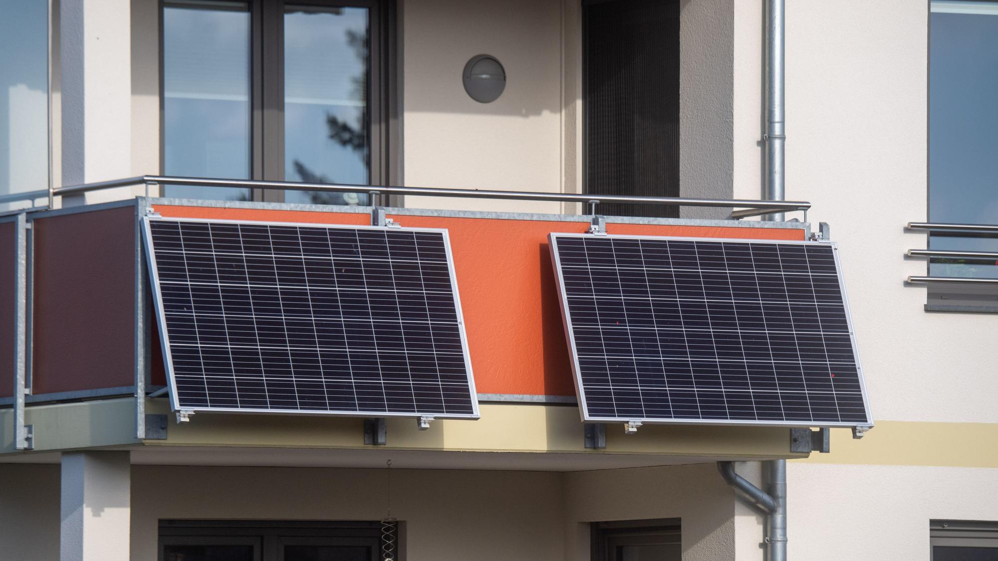 Solarmodule für ein sogenanntes Balkonkraftwerk hängen an einem Balkon.