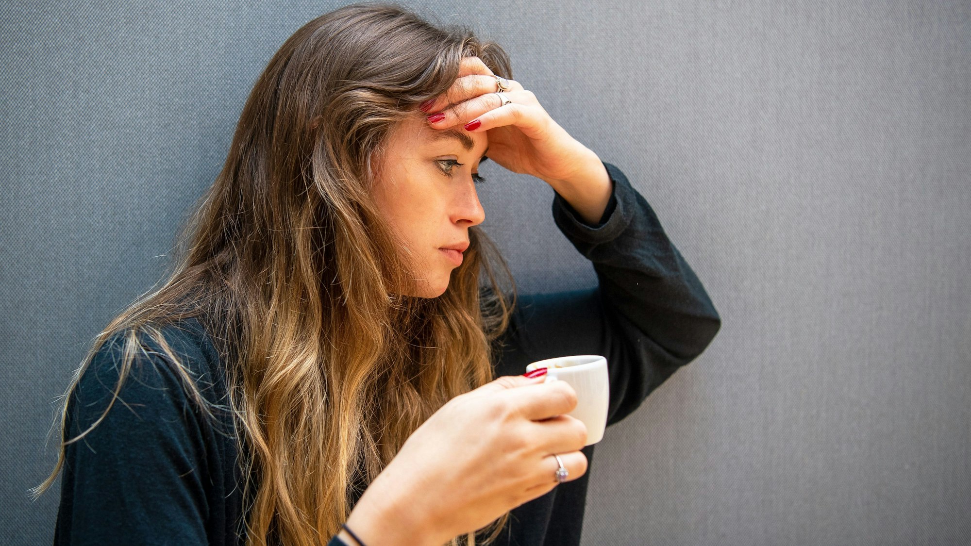 Eine Frau hält eine Tasse Espresso in der Hand.