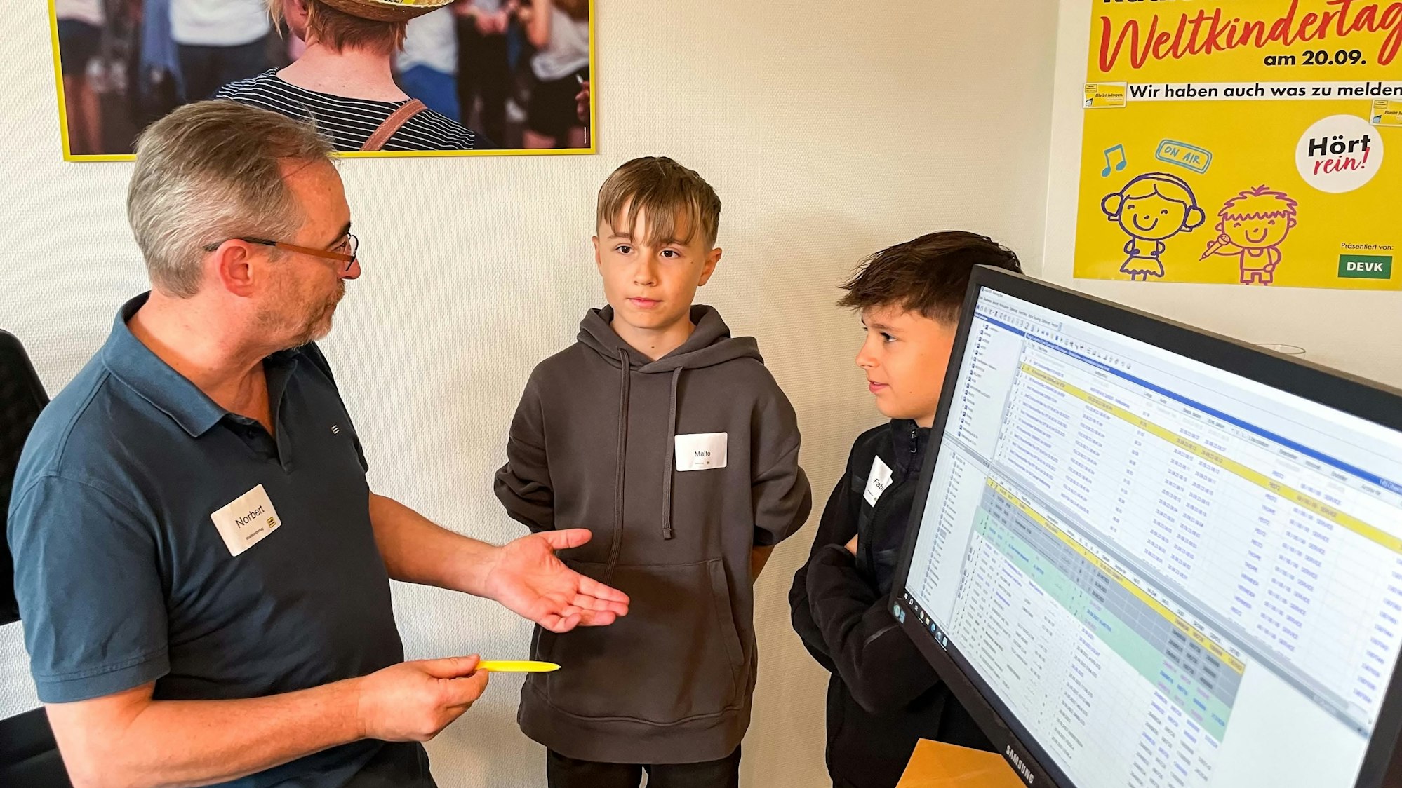 Das Bild zeigt Norbert Jeub, wie er mit den Schülern hinter dem Moderationspult spricht.