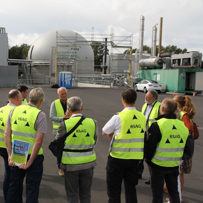 Eine Gruppe von Männern und Frauen in gelben Warnwesten vor der neuen Kompostanlage der RSAG