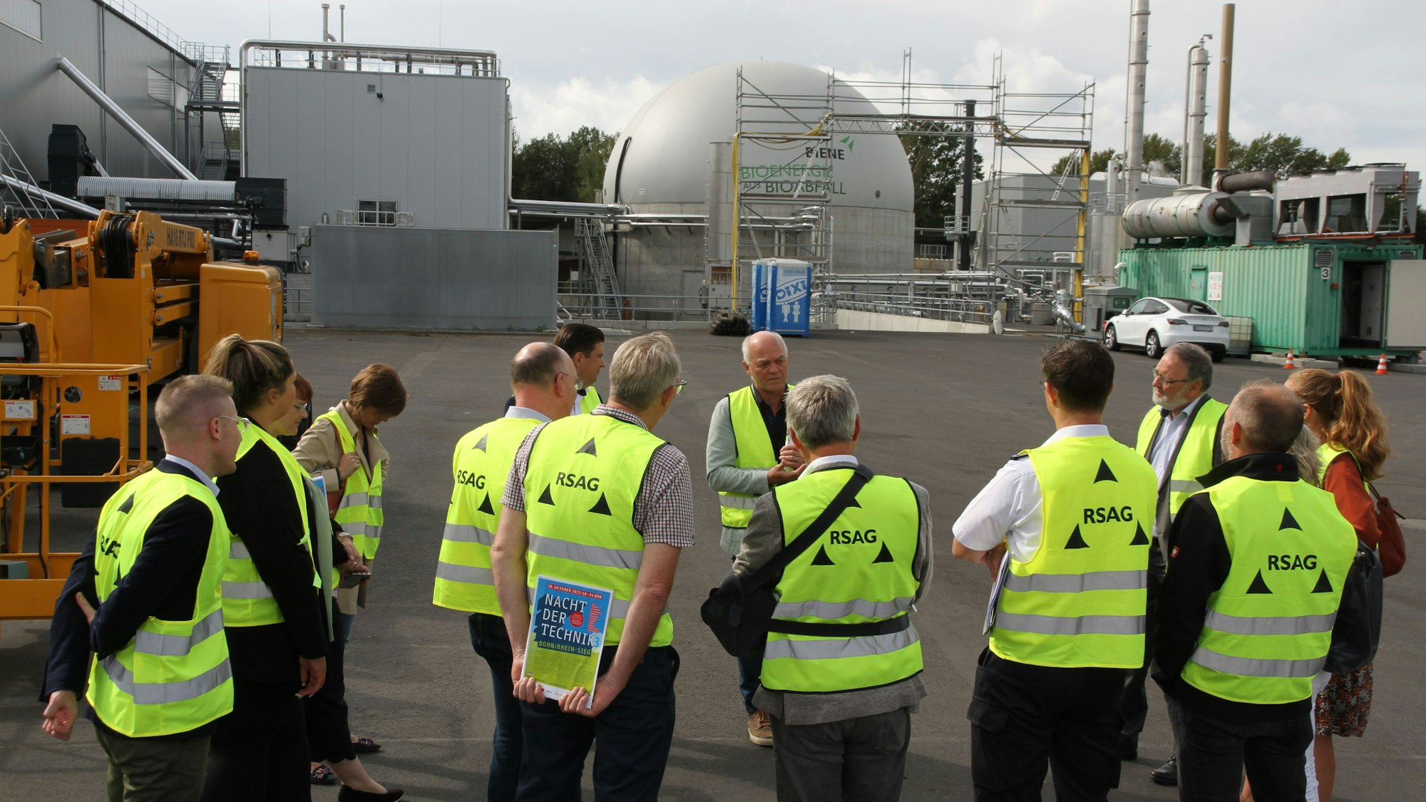 Eine Gruppe von Männern und Frauen in gelben Warnwesten vor der neuen Kompostanlage der RSAG