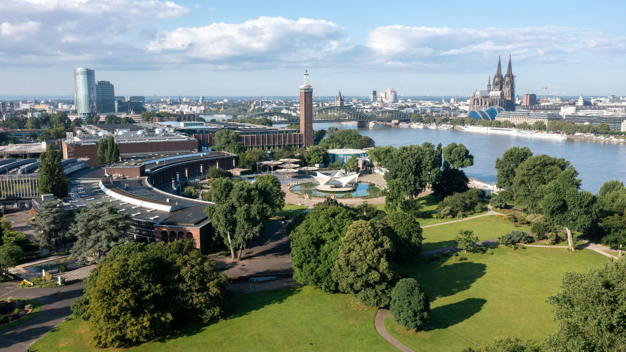 Eine Luftaufnahme zeigt den Rhein in Köln, daneben den Tanzbrunnen, den Kölner Dom und die Hohenzollernbrücke. (Symbolbild)